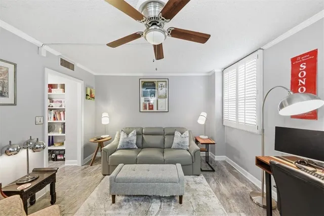 a living room with furniture a flat screen tv and a window
