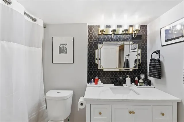 a bathroom with a sink vanity mirror and toilet