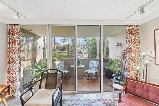 a view of a livingroom with furniture and floor to ceiling window