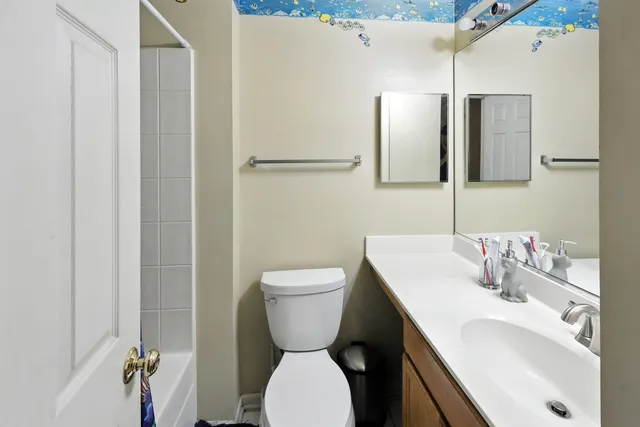 a bathroom with a toilet sink and mirror