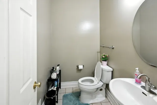 a bathroom with a toilet a sink and mirror