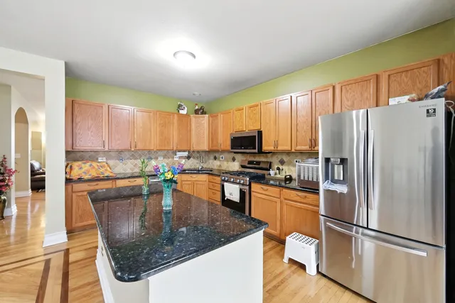 a kitchen with kitchen island a counter top space cabinets and stainless steel appliances