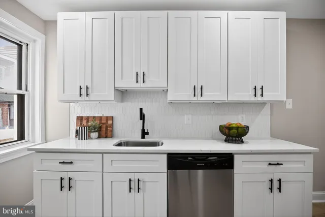 a kitchen with white cabinets and a wooden floor
