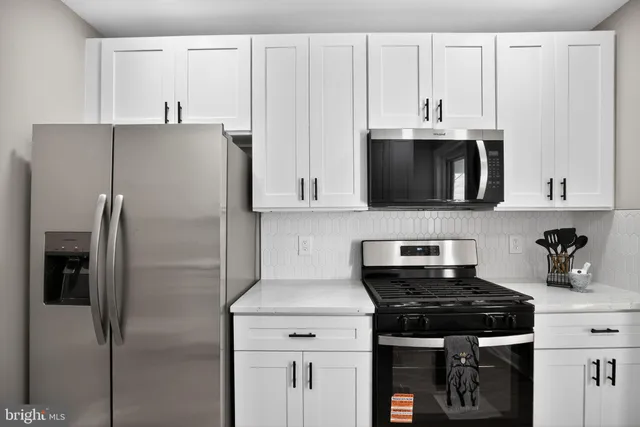 a kitchen with stainless steel appliances a refrigerator a stove top oven and cabinets