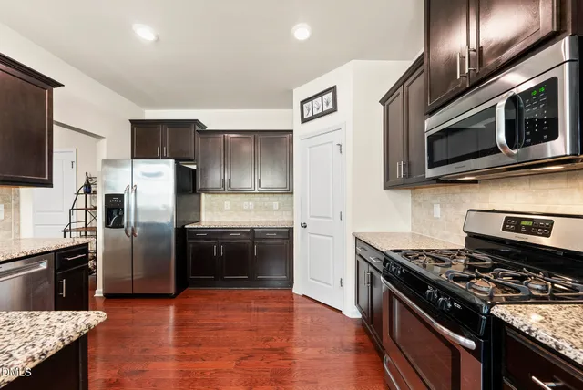 a kitchen with stainless steel appliances granite countertop a stove microwave sink and refrigerator