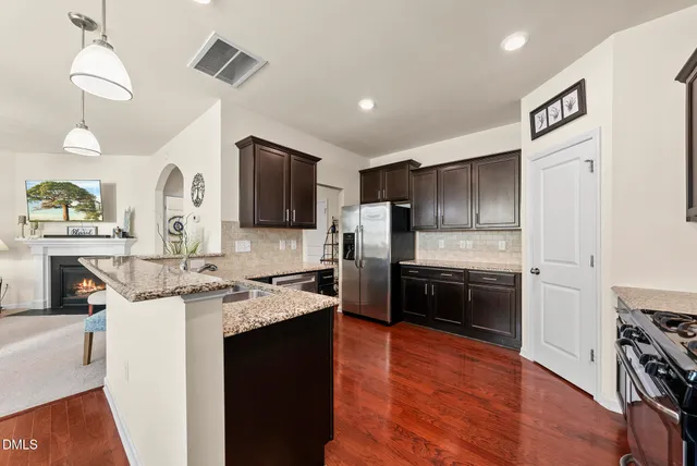 a kitchen with stainless steel appliances kitchen island granite countertop a stove sink and cabinets