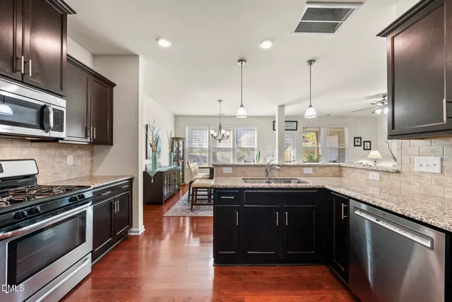 a kitchen with stainless steel appliances granite countertop a sink and stove