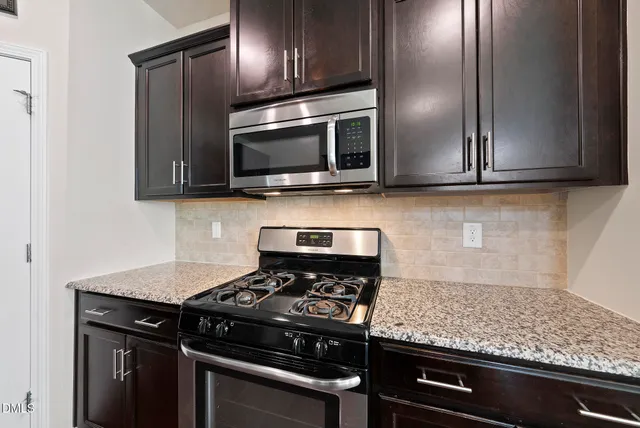 a kitchen with granite countertop stainless steel appliances and wooden cabinets