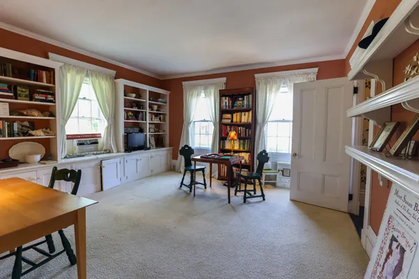 a living room with furniture a potted plant and open kitchen view