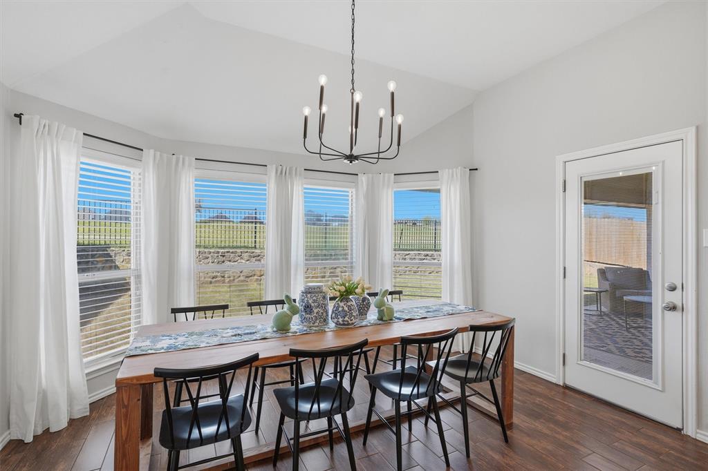 7224 Prestwick Terrace Benbrook, TX 76126 - Photo 4 of 26 a dining room with wooden floor a chandelier a wooden table and chairs