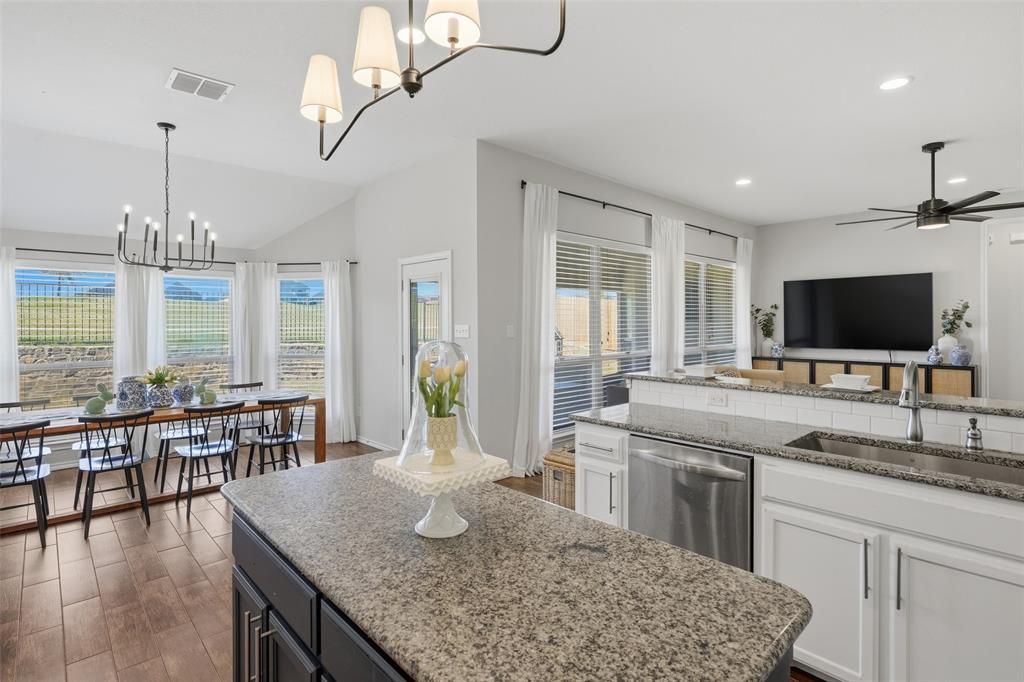 7224 Prestwick Terrace Benbrook, TX 76126 - Photo 8 of 26 a kitchen with granite countertop a stove a sink a dining table and chairs with wooden floor