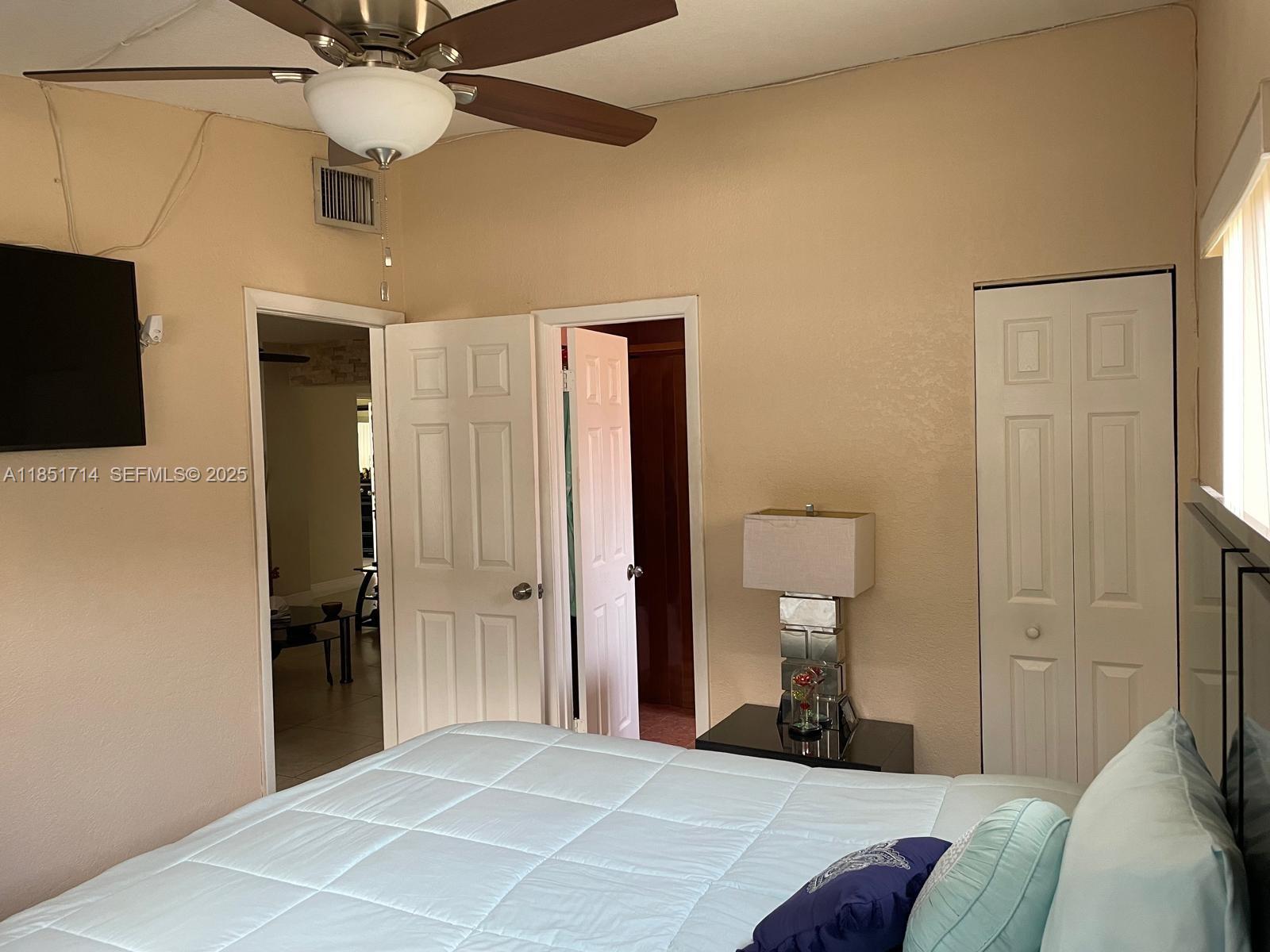 1847 West 2nd Avenue Hialeah, FL 33010 - Photo 17 of 27 a bedroom with a bed and a chandelier