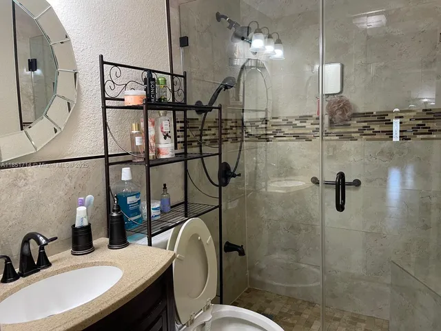 a bathroom with a sink a toilet and shower