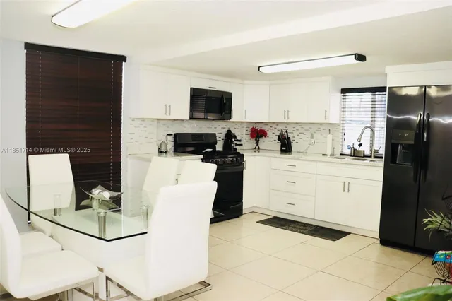 a kitchen with a refrigerator a stove top oven and cabinets