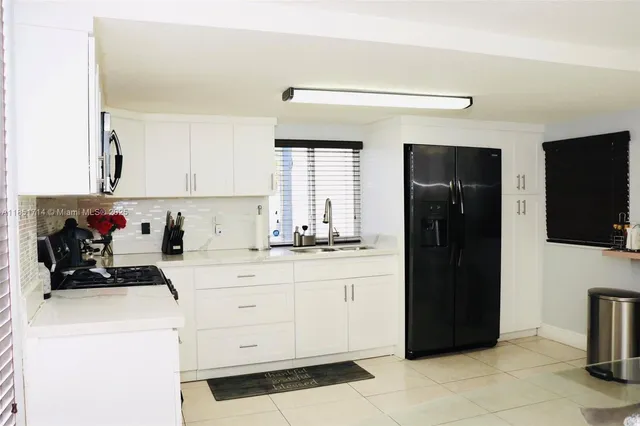 a kitchen with a refrigerator and a sink