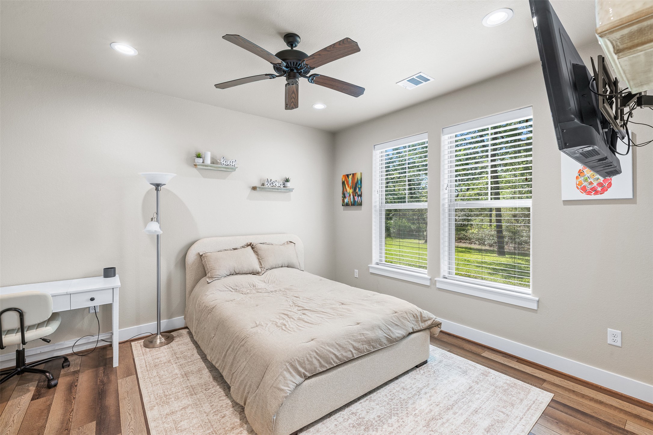1306 22 Hills Road Gause, TX 77857 - Photo 27 of 40 Bedroom featuring two windows with horizontal blinds, wood-finish flooring, and a ceiling fan with integrated lighting