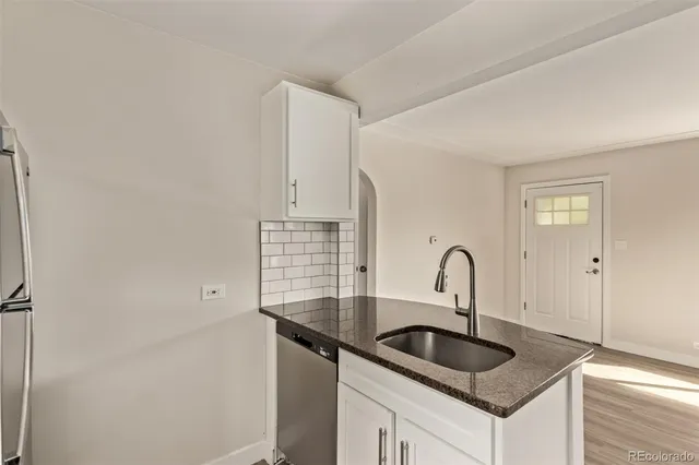 a kitchen with granite countertop a sink and cabinets