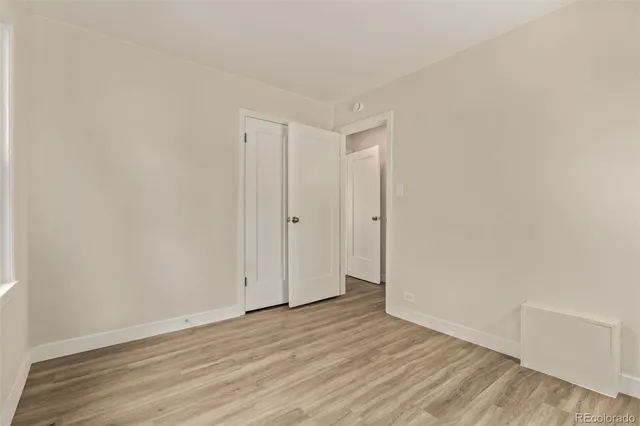 a view of an empty room with wooden floor