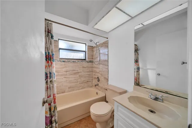 a bathroom with a bathtub shower sink vanity mirror and toilet