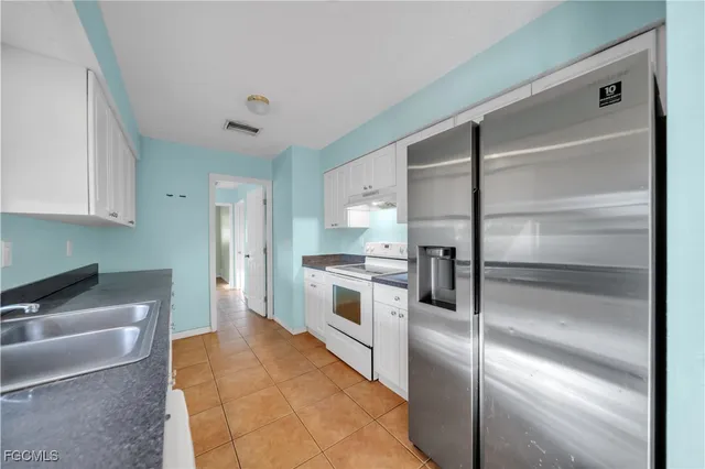 a kitchen with a refrigerator and a sink