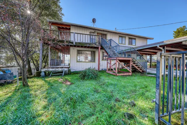 a view of a house with backyard and a tree