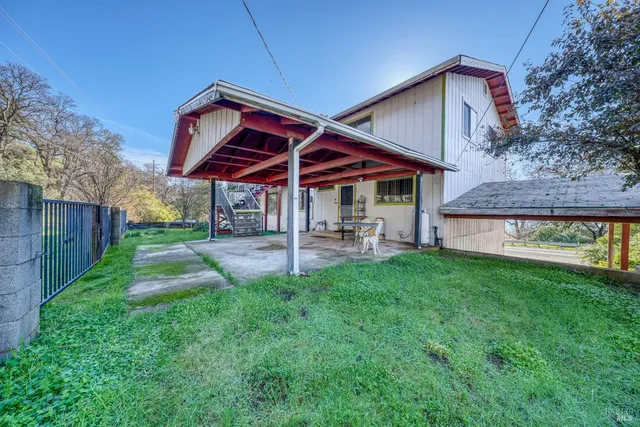 a view of a house with backyard and sitting area