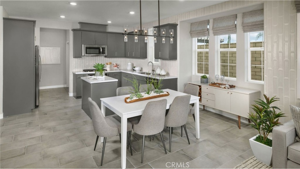 2109 Crescent Moon Upland, CA 91786 - Photo 3 of 17 a dining room with stainless steel appliances kitchen island granite countertop a dining table chairs and a refrigerator