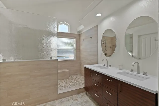 a bathroom with a sink toilet double vanity and shower
