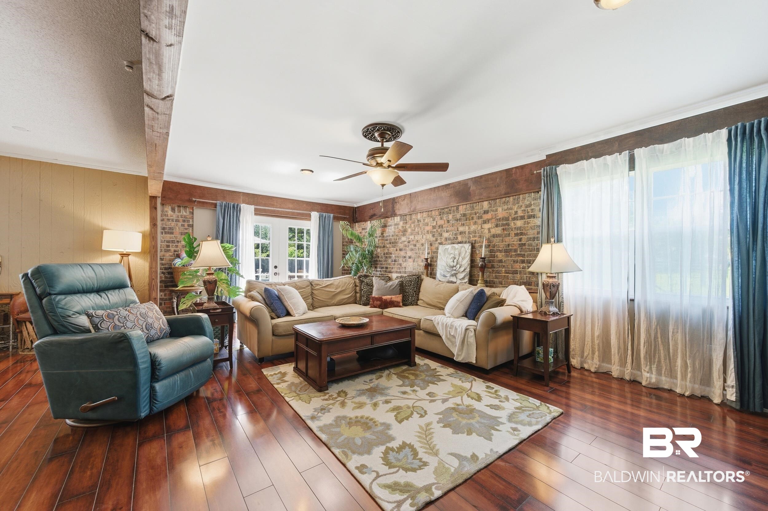 51620 Robert White Road Bay Minette, AL 36507 - Photo 29 of 81 Spacious living area featuring wood-finish flooring, exposed ceiling beams, and a brick accent wall