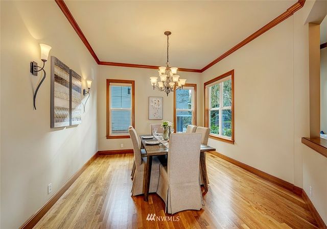 a dining room with furniture a chandelier and wooden floor