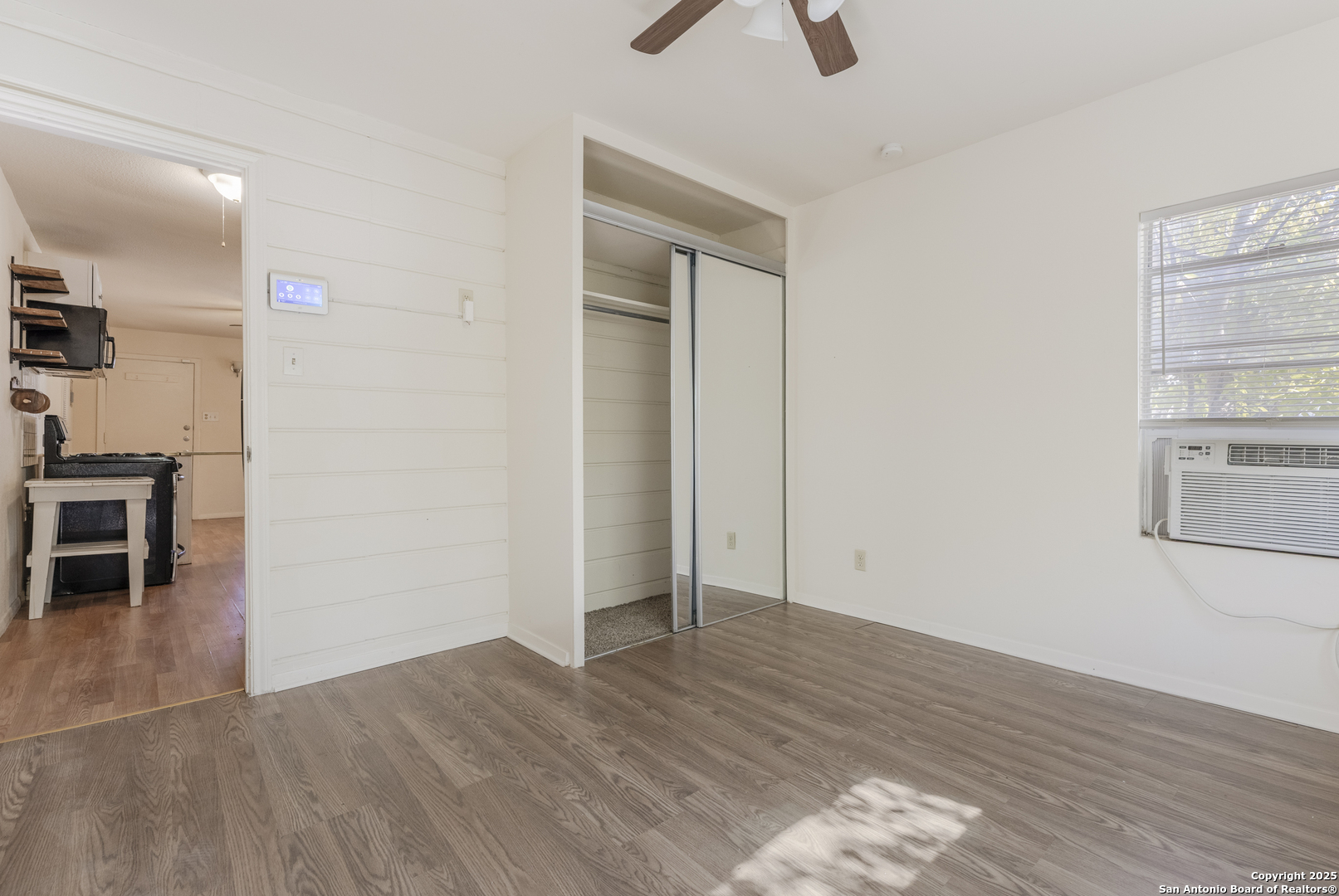 308 West Theo Avenue, Unit 2 San Antonio, TX 78214 - Photo 11 of 17 an empty room with wooden floor cabinet and windows