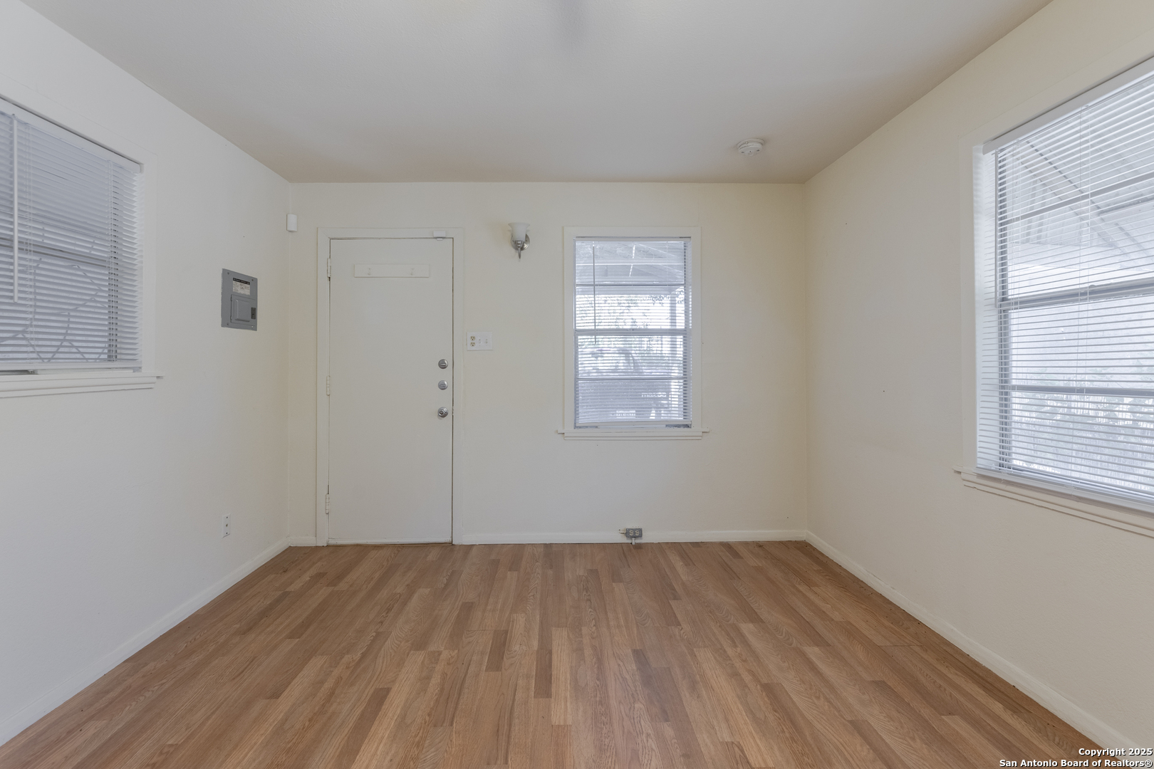 308 West Theo Avenue, Unit 2 San Antonio, TX 78214 - Photo 4 of 17 an empty room with wooden floor and windows