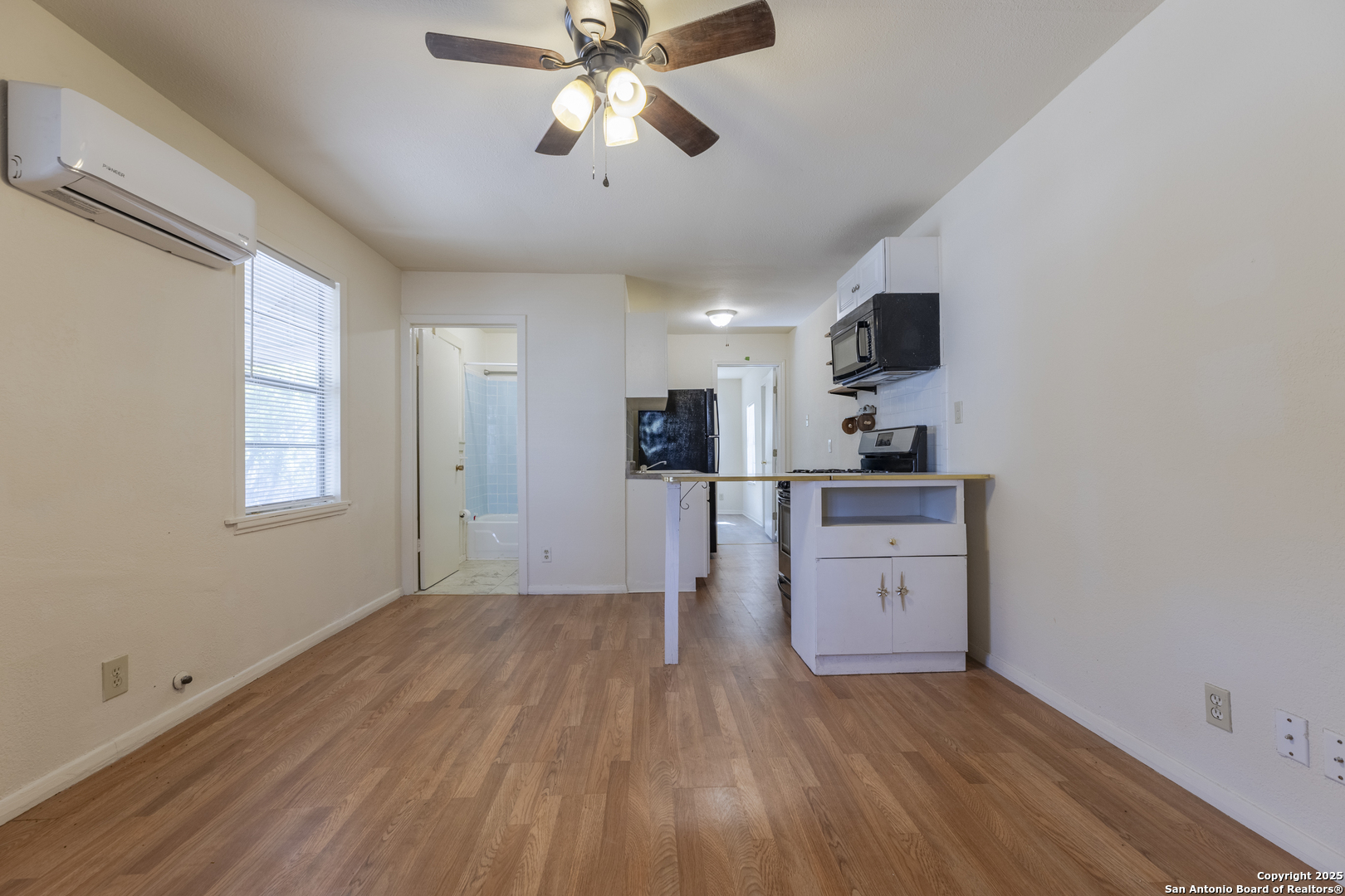 308 West Theo Avenue, Unit 2 San Antonio, TX 78214 - Photo 6 of 17 a view of a kitchen with a microwave and a ceiling fan