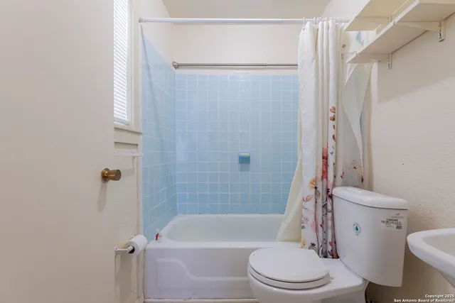 a white toilet sitting next to a bath tub