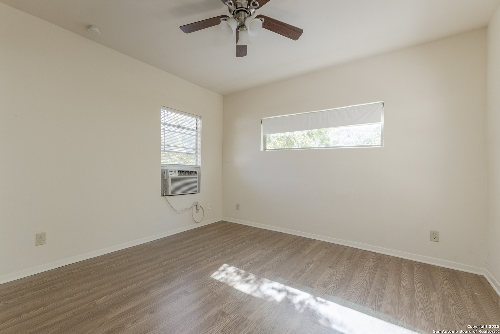 308 West Theo Avenue, Unit 2 San Antonio, TX 78214 - Photo 10 of 17 wooden floor in an empty room with a window