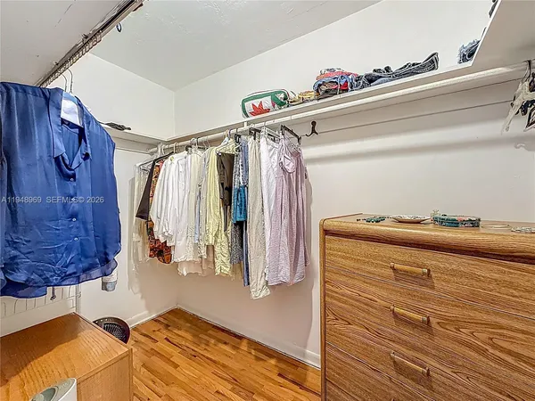 a view of walk in closet with clothes and shoes