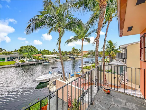 a view of a lake with boats and palm trees