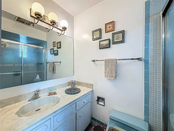 a bathroom with a sink and mirror with toilet