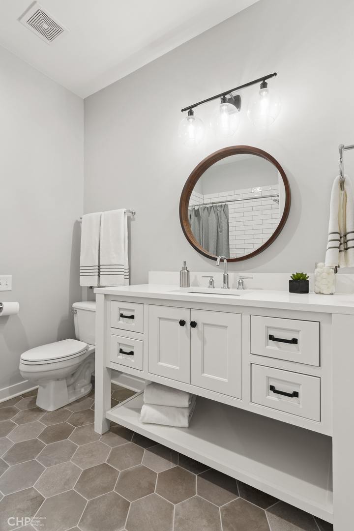 1354 West Fillmore Street, Unit A Chicago, IL 60607 - Photo 11 of 15 a bathroom with a toilet a sink and mirror