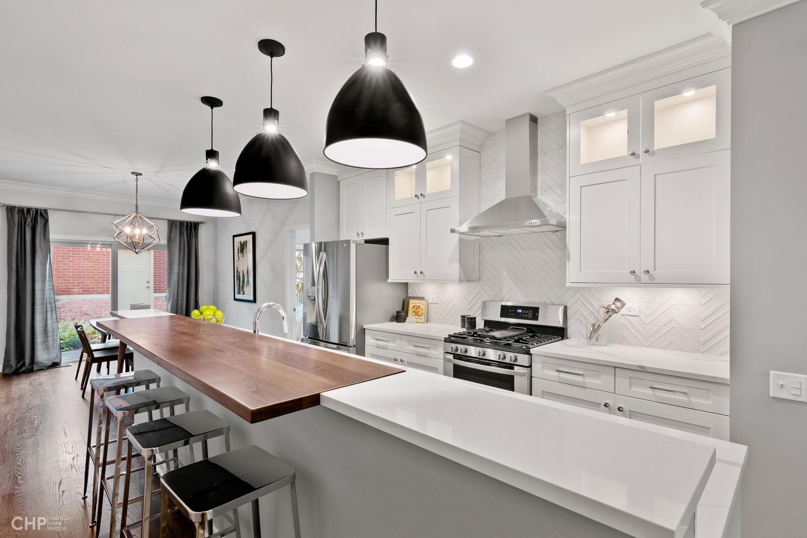 1354 West Fillmore Street, Unit A Chicago, IL 60607 - Photo 4 of 15 a kitchen with stainless steel appliances a stove a table and chairs