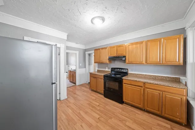 a kitchen with a sink appliances cabinets and a window
