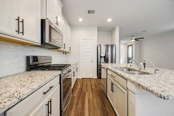 a kitchen with stainless steel appliances granite countertop a stove and a sink