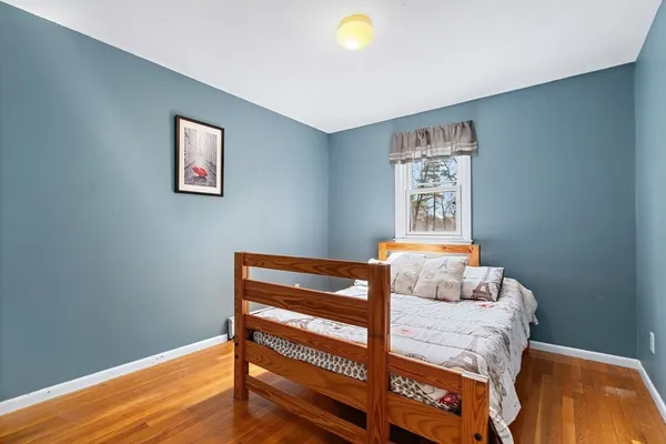a bedroom with a bed and wooden floor