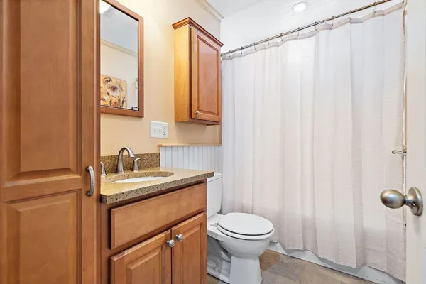 a bathroom with a sink a toilet and shower