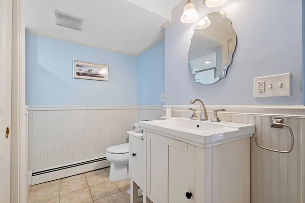 a bathroom with a toilet a sink and mirror
