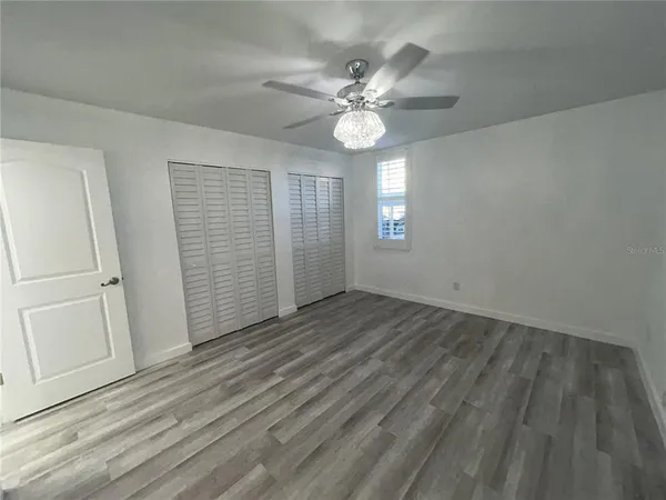 a bathroom with a granite countertop sink a toilet a mirror and shower