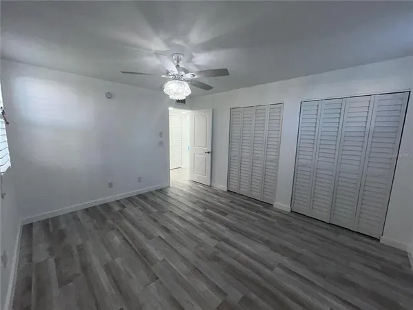a bathroom with a granite countertop sink a toilet a mirror and bathtub