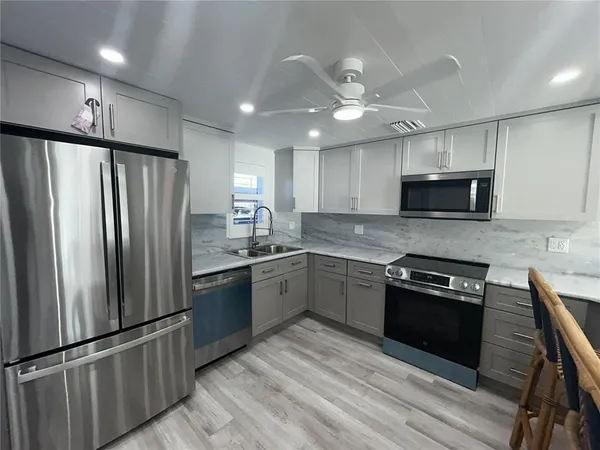 a kitchen with granite countertop stainless steel appliances and wooden cabinets