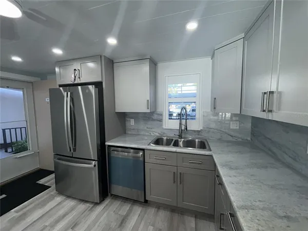 a kitchen with kitchen island a sink appliances and cabinets