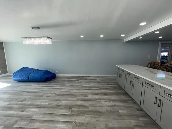 a spacious bedroom with a bed and a chandelier